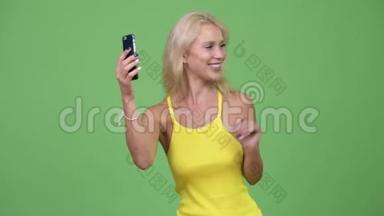 年轻快乐的金发美女视频通话显示电话